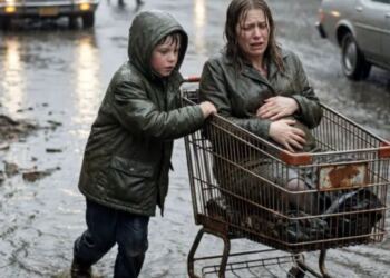 Όταν τα αυτοκίνητα προσπερνούσαν μια έγκυο γυναίκα σε πλημμυρισμένο δρόμο, ένα άστεγο αγόρι βγήκε στη βροχή να τη βοηθήσει. Λίγες μέρες αργότερα, ένα SUV σταμάτησε έξω από το συσσίτιο — και εκείνος πάγωσε.